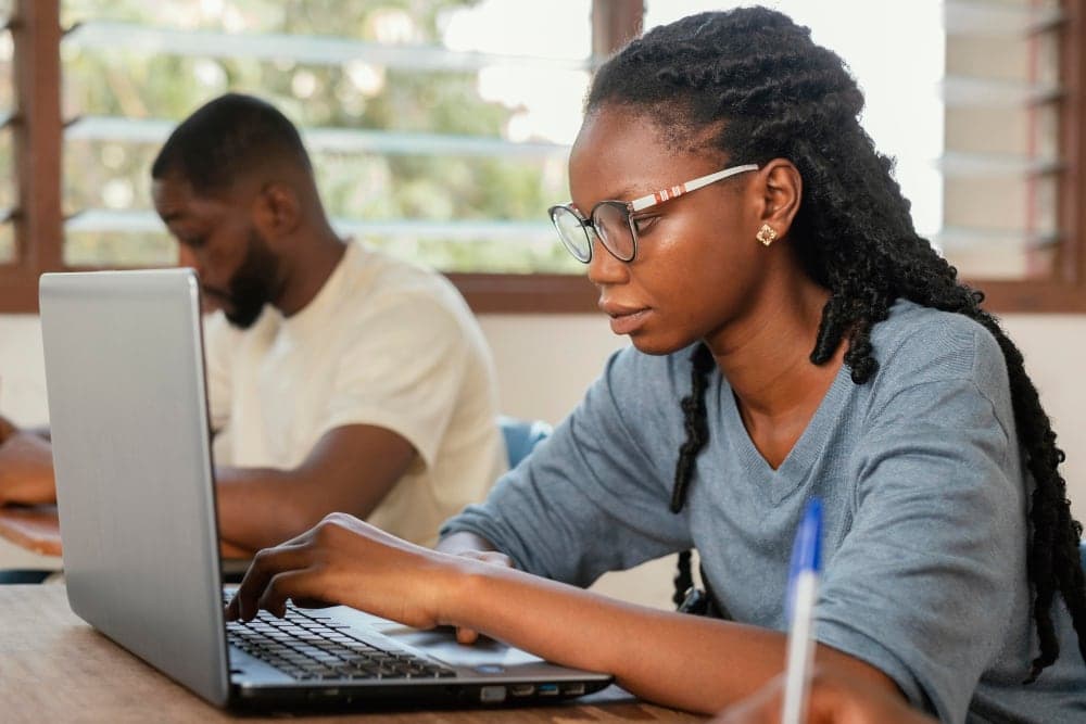 Two students working at desktop computers in a computer lab