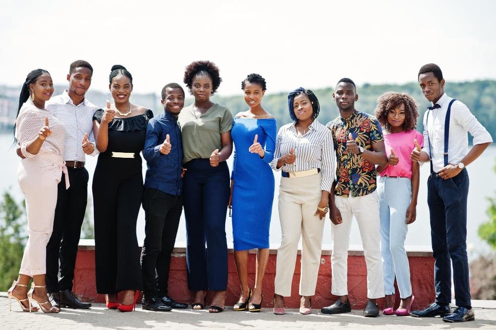A group of young professionals in formal dress standing together for a photograph