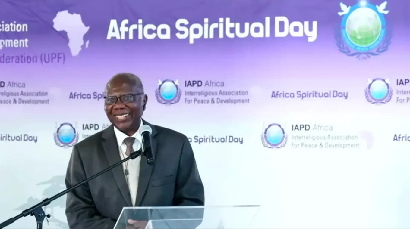 A speaker addressing Africa Spiritual Day from the podium, in front of an IAPD Africa backdrop.